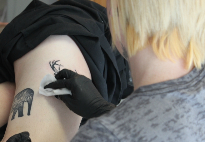 Carmin working on Lydia's tattoo